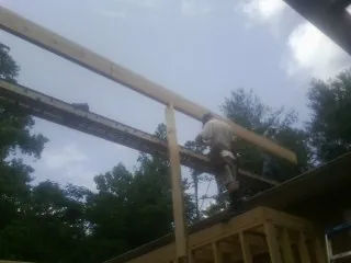 Carpenter setting a ridge beam over a new addition frame — Ice Dam Removal by Roofing Brothers in Cardinal
