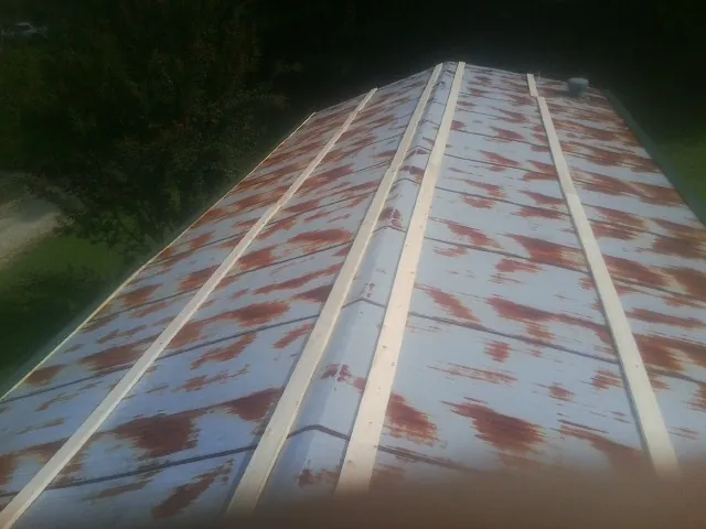 Rusted metal roof panels with new wood purlins before replacement — Storm Damage Roof Repair in Cardinal by Roofing Brothers