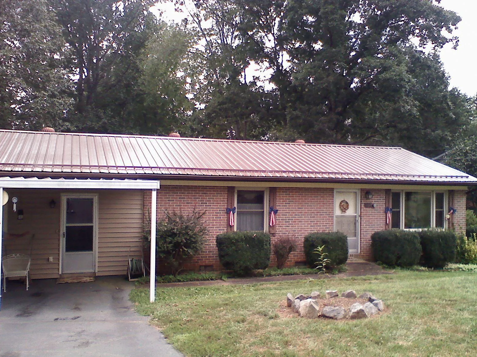 Bronze metal roof and carport on a brick ranch home — Roof Repair work by our crew in Cardinal